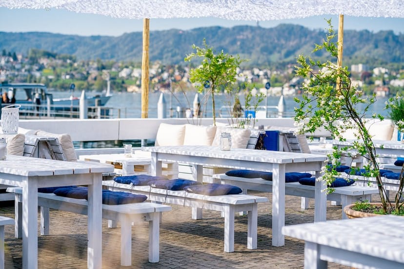 Stylish waterfront venue with white furniture for outdoor cocktail receptions