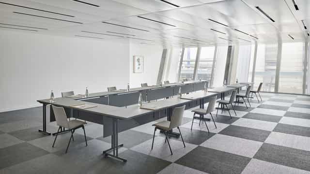 Modern corporate seminar room with natural light, ideal for meetings and presentations.