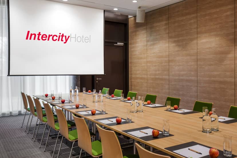 "Seminar Room Felsenegg with long table and green chairs for professional events."