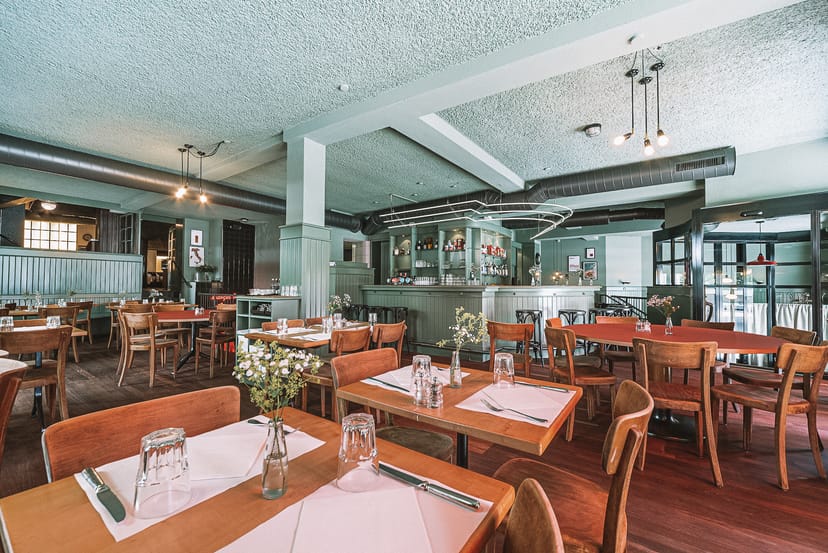 Elegant restaurant venue in Commihalle for events and meetings with wooden tables.