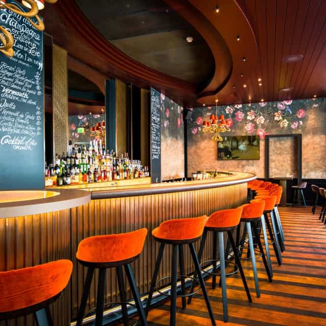 Stylish bar in Carlton Restaurant with floral backdrop, perfect for cocktail receptions.