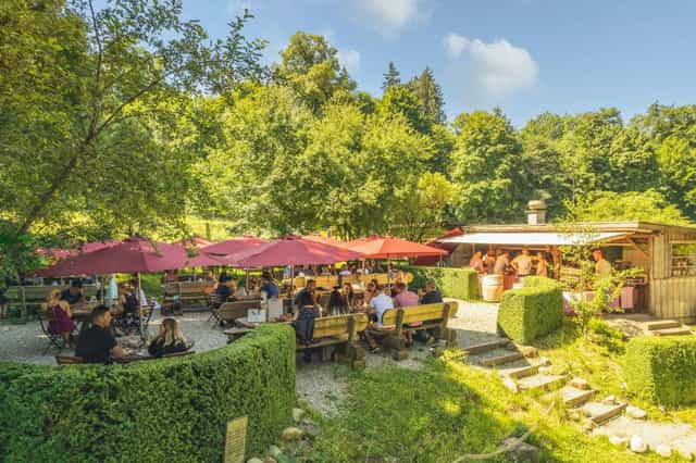 Kuhstall outdoor event space with shaded seating, perfect for summer gatherings and networking.