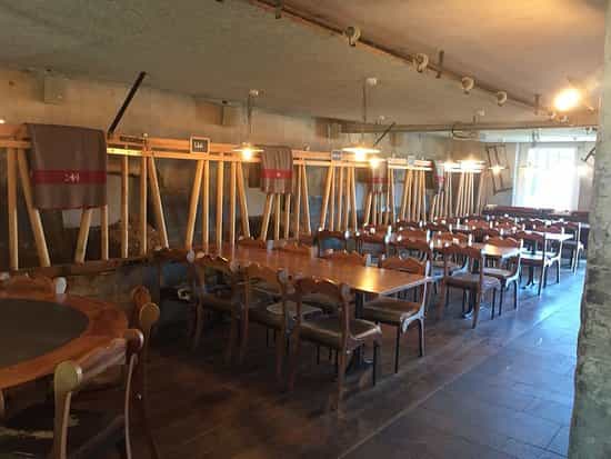 Rustic dining space at Kuhstall, warm lighting, ideal for gatherings and celebrations.