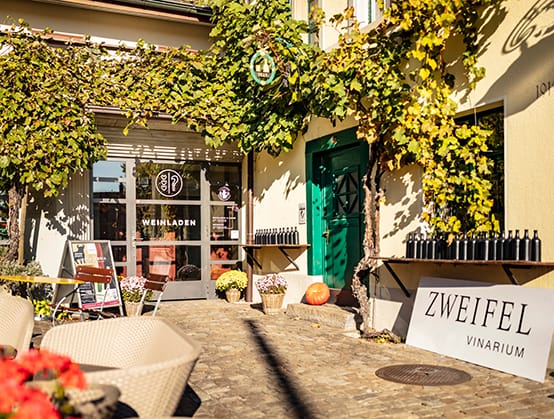 Inviting wine shop patio with grapevines, ideal for tastings and local events.