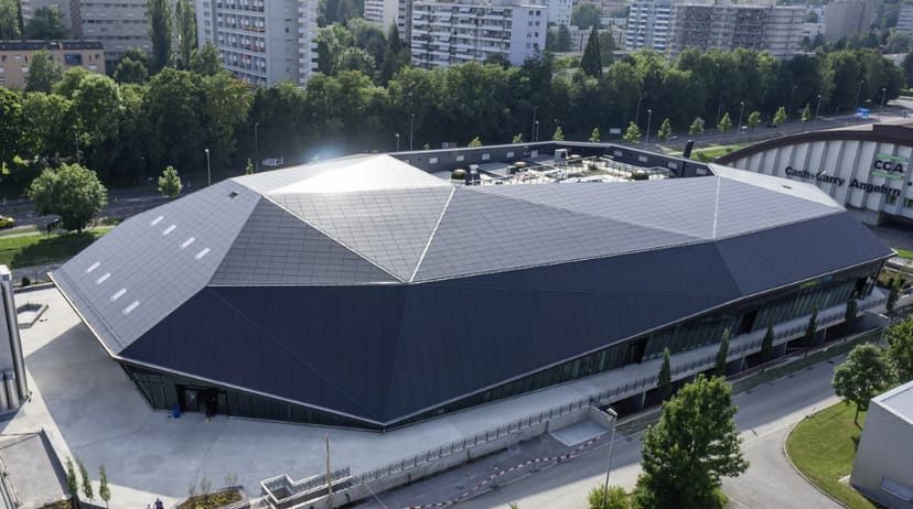 Modern event venue at Umwelt Arena Schweiz features solar panel roofing, perfect for conferences.