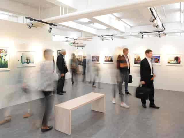 Art exhibition in modern Photobastei space with engaged attendees, ideal for networking.