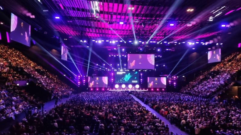 Packed St. Jakobshalle Basel auditorium with vibrant lighting for engaging events.
