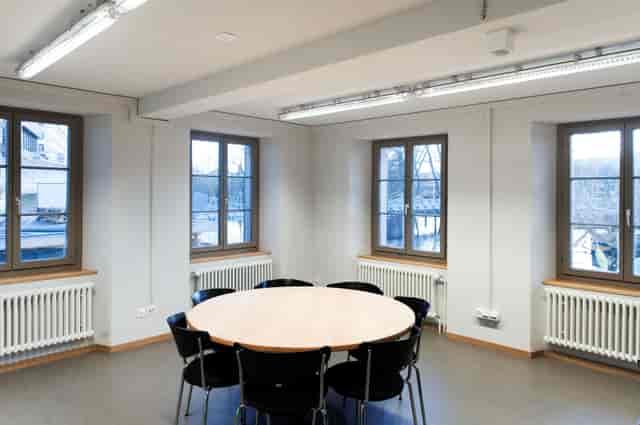 Minimalist meeting room in Dynamo Zürich with round table, ideal for workshops and discussions.