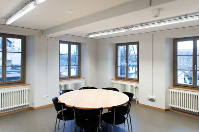 Minimalist meeting room in Dynamo Zürich with round table, ideal for workshops and discussions.