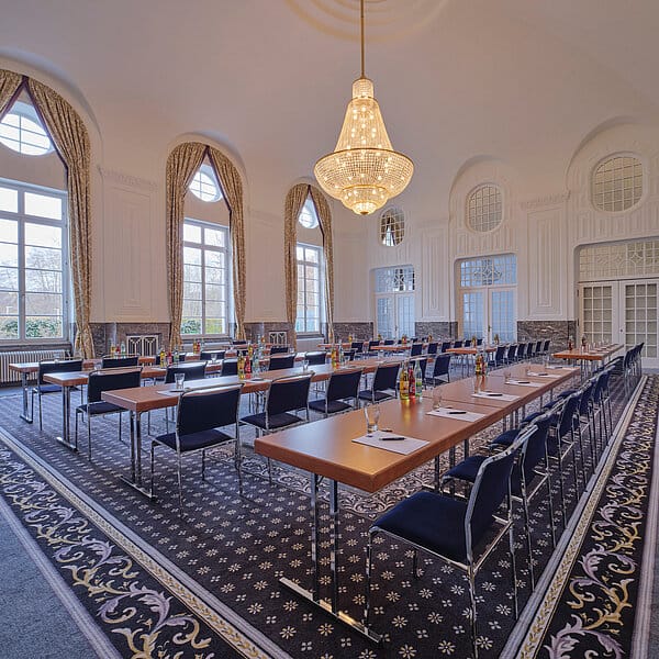 Elegant banquet hall with natural light, ideal for professional workshops and presentations.