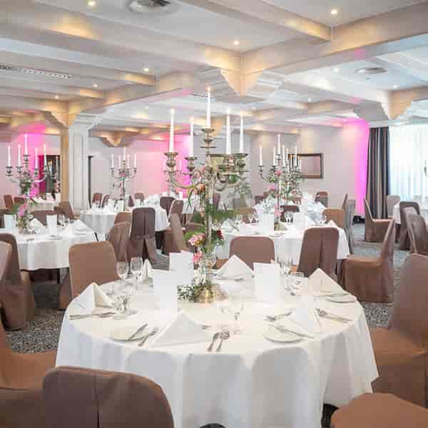Elegant banquet hall at Dorint Tagungshotels with charming white table setups.