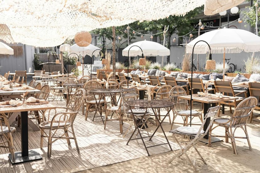 Stylish outdoor café event space with rattan furniture, ideal for brunch and gatherings.