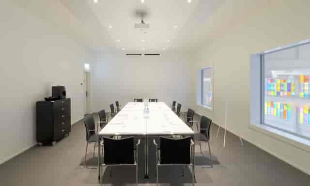 Modern meeting room in Trafo Baden with large windows, ideal for workshops and presentations.