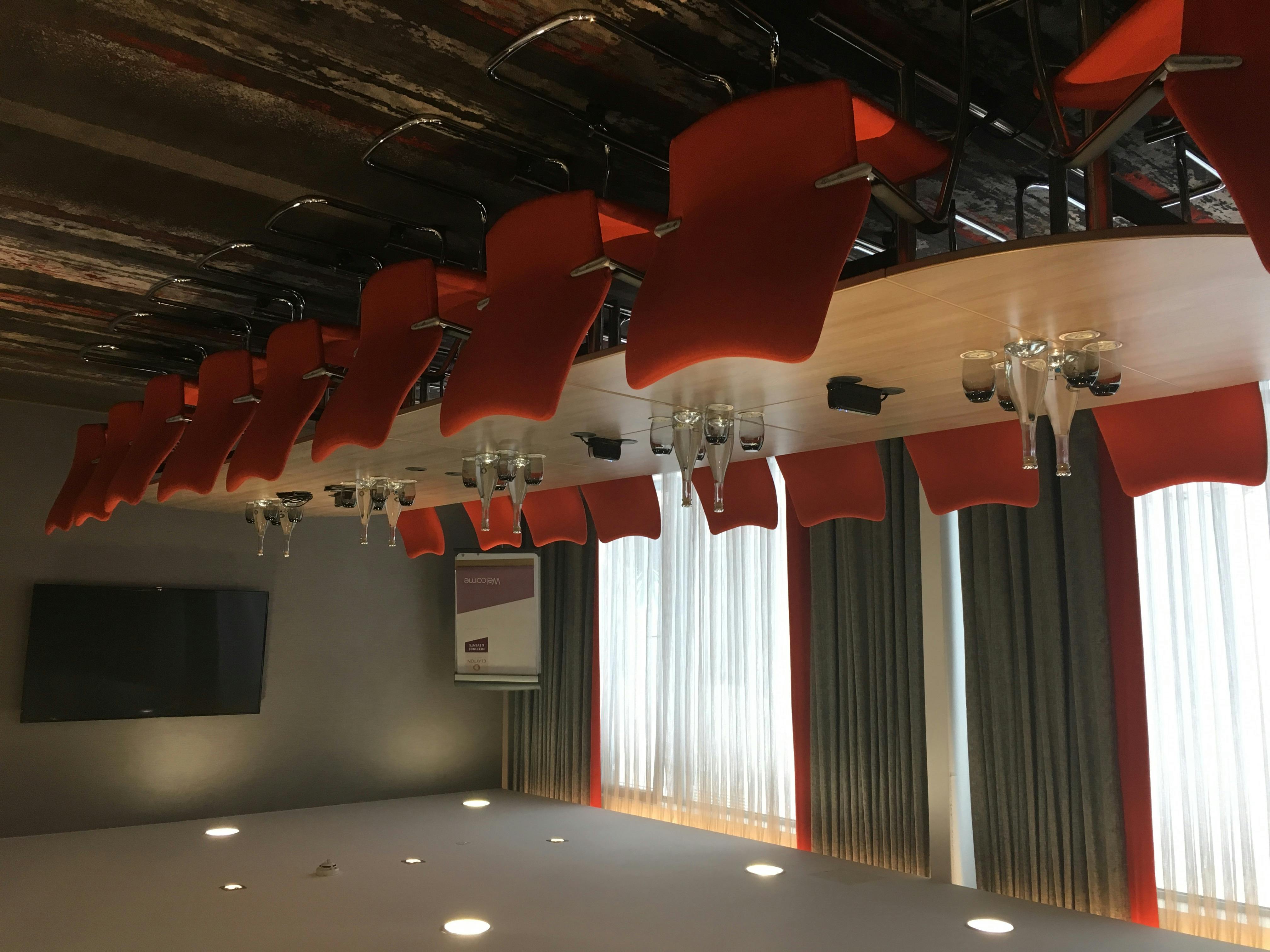 Modern Gunnersbury Suite meeting room with red chairs, ideal for workshops and discussions.