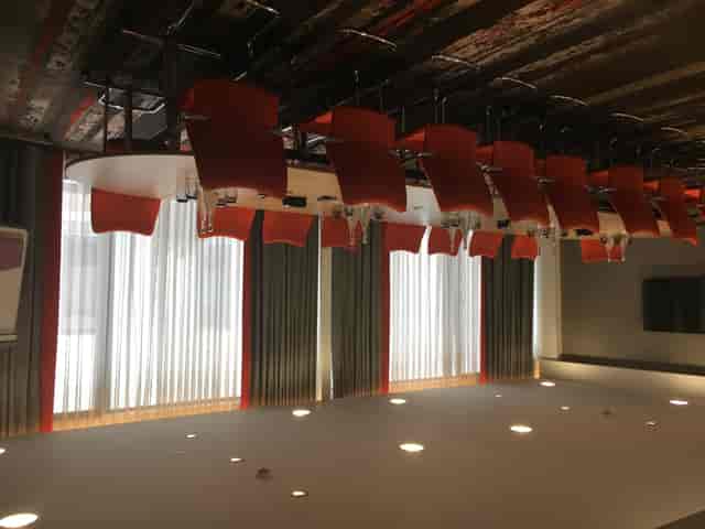 Modern Gunnersbury Suite meeting room with orange chairs and natural light, ideal for events.