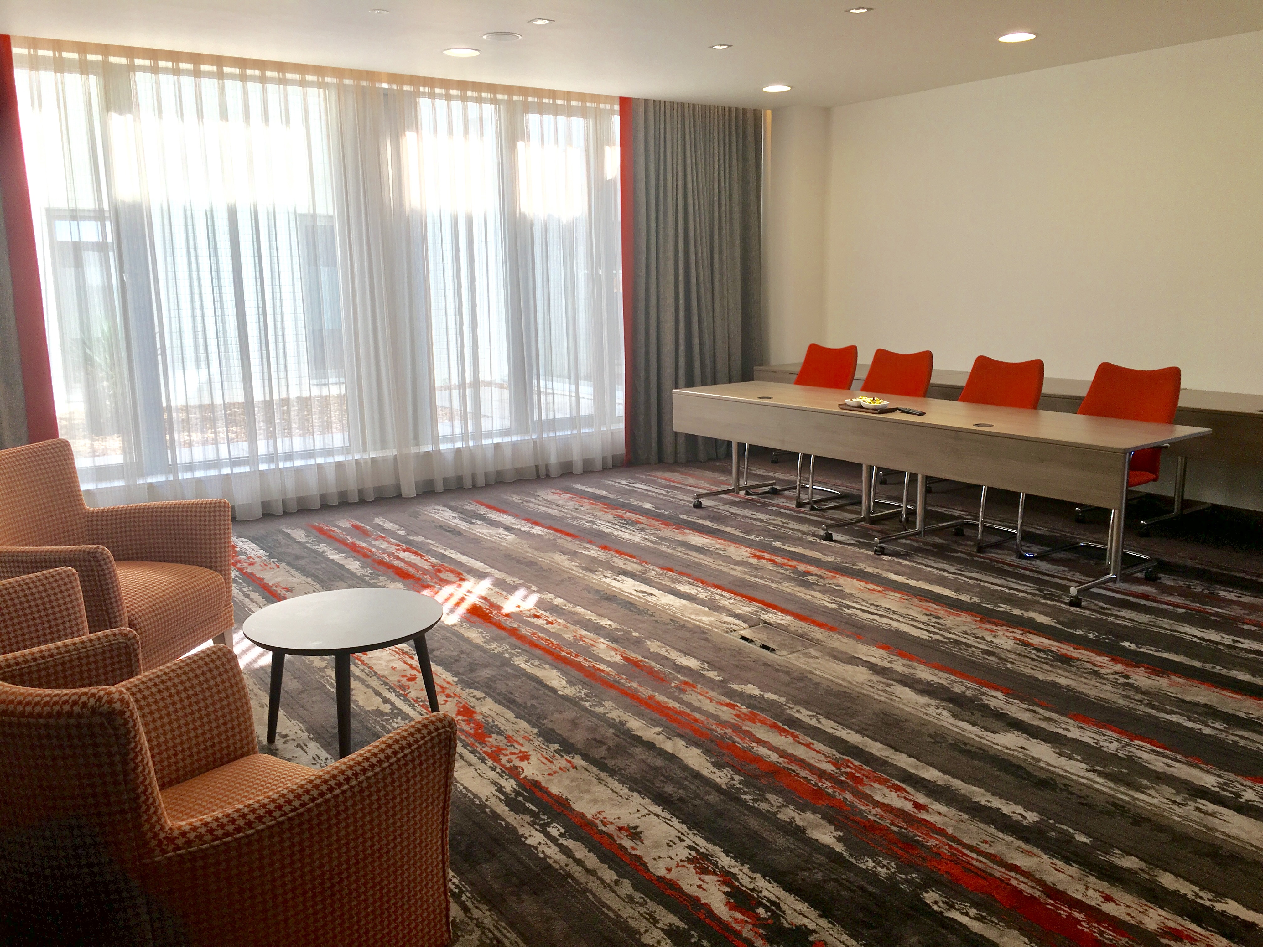Devonshire Suite at Clayton Hotel Chiswick, modern meeting space with orange chairs. - Banner