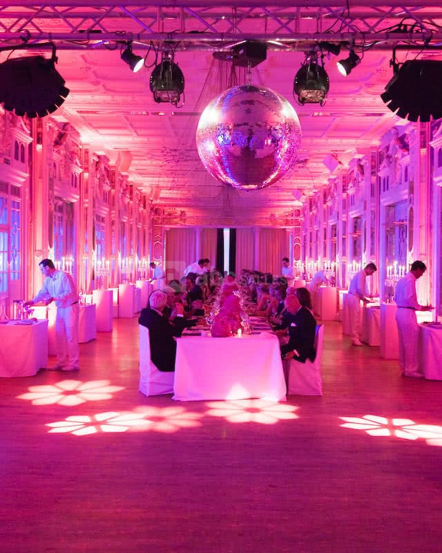 Elegant function room with white linens, disco ball, perfect for events and networking.