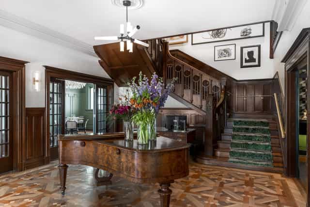 Elegant library foyer with grand staircase, perfect for upscale events and gatherings.