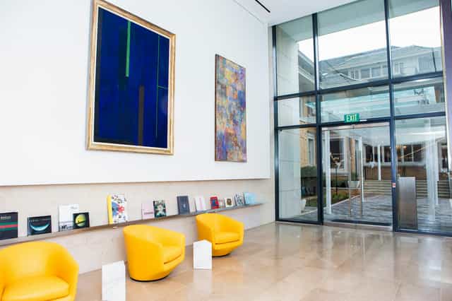 Modern library entryway with yellow chairs, ideal for networking events and meetings.