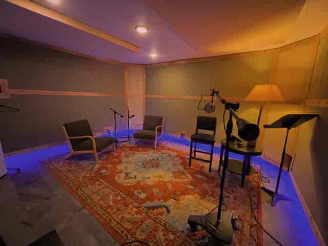 Cozy soundproof studio for podcasts and workshops with inviting seating and creative lighting.