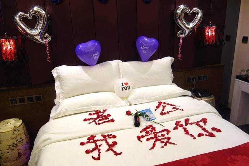 Romantic hotel room with heart-shaped balloons for anniversaries and proposals.