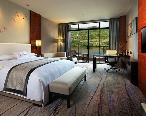 "Luxury hotel suite with large windows, ideal for corporate retreats and meetings."