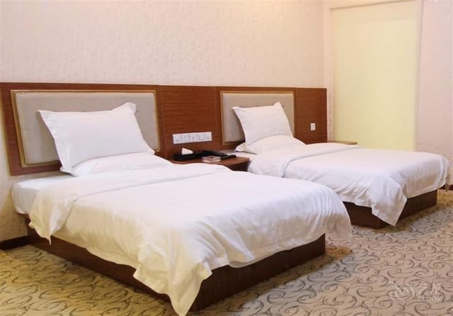 Hotel room in Deyu Business Hotel Guangzhou, with two beds for seminars and retreats