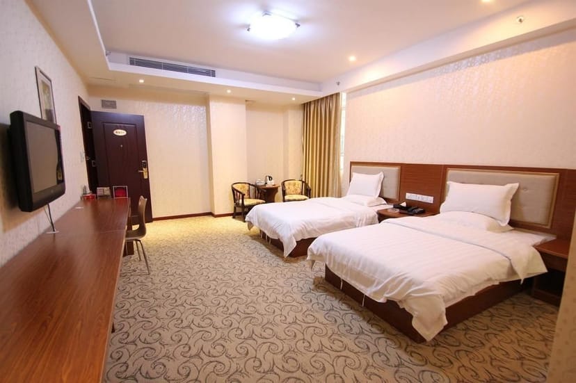 Twin bed hotel room in Deyu Business Hotel, ideal for events and business travelers.