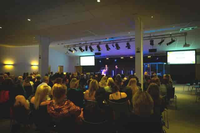 Riverside Conferencing auditorium event with professional lighting and engaged attendees.