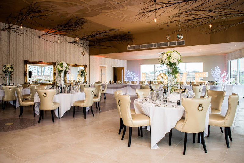Elegant event space with round tables, ideal for weddings and corporate events. - Banner