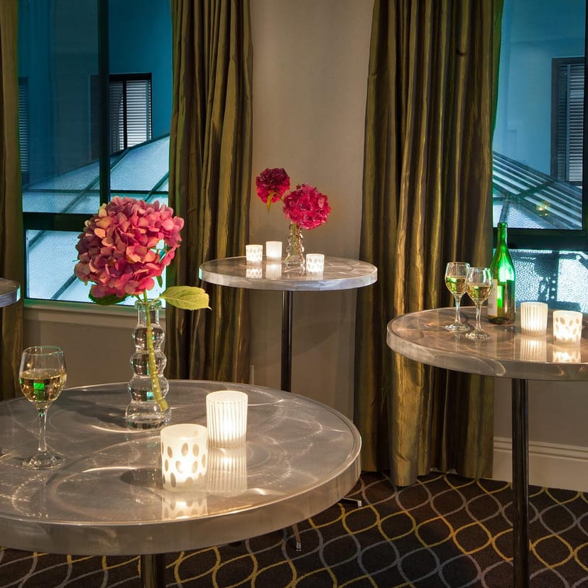 Stylish cocktail event setup at Galleria Park Hotel with floral centerpieces and warm lighting.