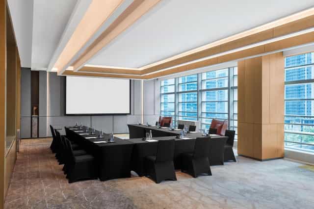Modern conference room in Panyu Hotel, featuring a U-shaped table for corporate meetings.