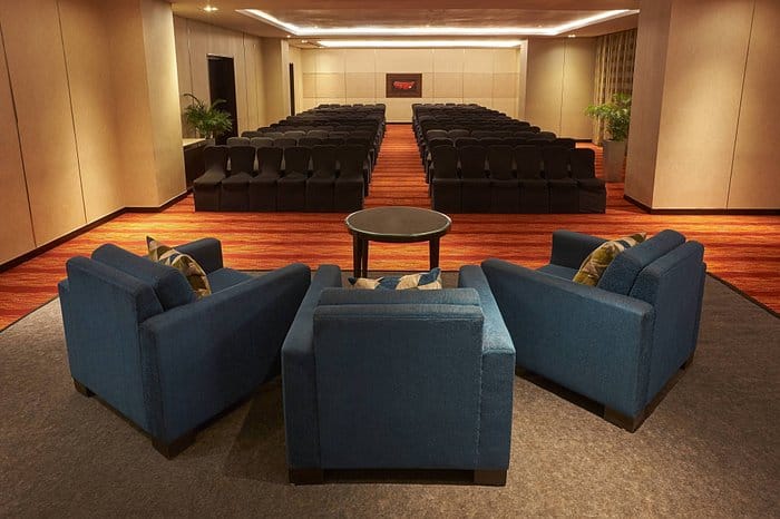 Conference room with blue lounge chairs at Courtyard Mumbai Airport for events.