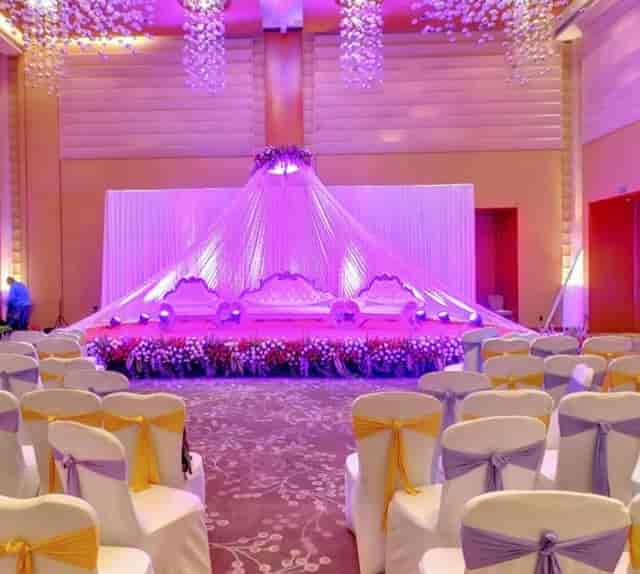 Elegant wedding banquet at Courtyard Mumbai Airport with purple lighting and floral decor.
