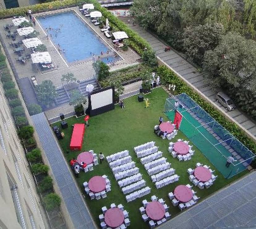 Outdoor banquet at Courtyard Mumbai Airport with red linen tables and poolside seating.