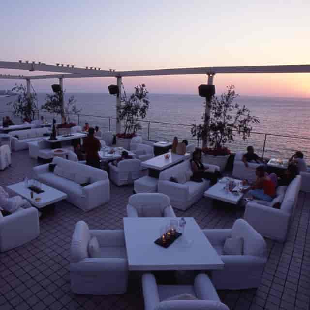 Chic outdoor restaurant with ocean view at sunset, perfect for upscale events and receptions.