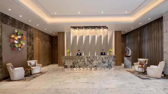 Modern hotel lobby in Radisson Mumbai with elegant marble reception, ideal for events.