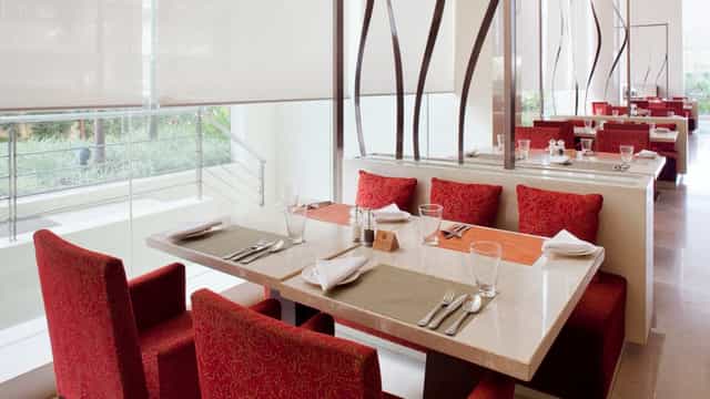Meeting Room 6 at Holiday Inn Mumbai: elegant dining area with red upholstery for meetings.