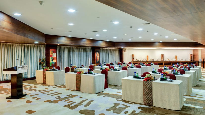 Banquet conference room at Hotel Sahara Star with elegant tables for corporate events.