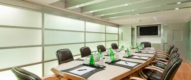 Modern Hilton Mumbai airport boardroom with sleek table, ideal for meetings and presentations.