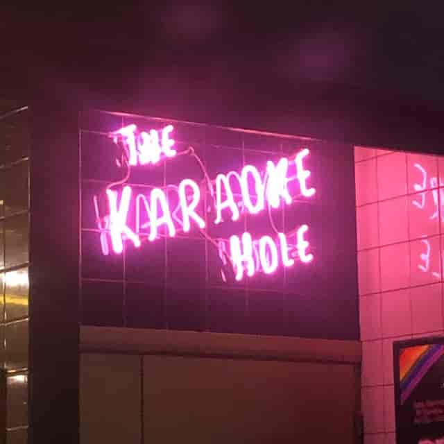 Vibrant neon "The Karaoke Hole" sign in The Light Redhill for lively events.