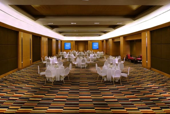 Elegant event space at The LaLiT Ashok Bangalore with round tables for corporate meetings and banquets.