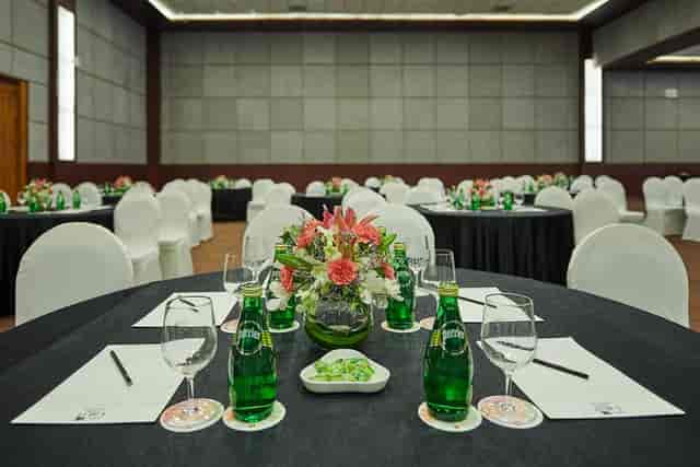 Elegant meeting setup with round tables and floral centerpieces at The LaLiT Ashok Bangalore.