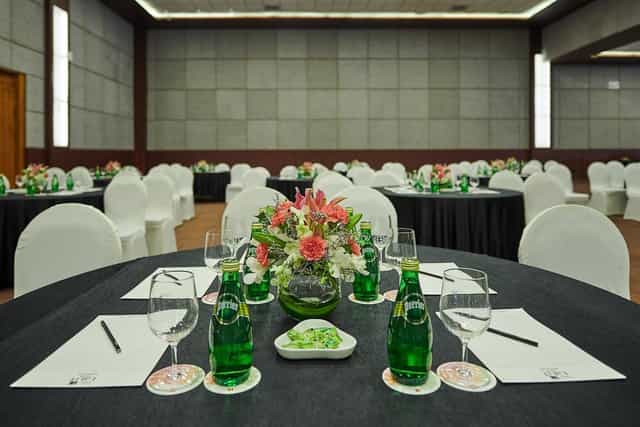 Elegant meeting setup with round tables and floral centerpieces at The LaLiT Ashok Bangalore.
