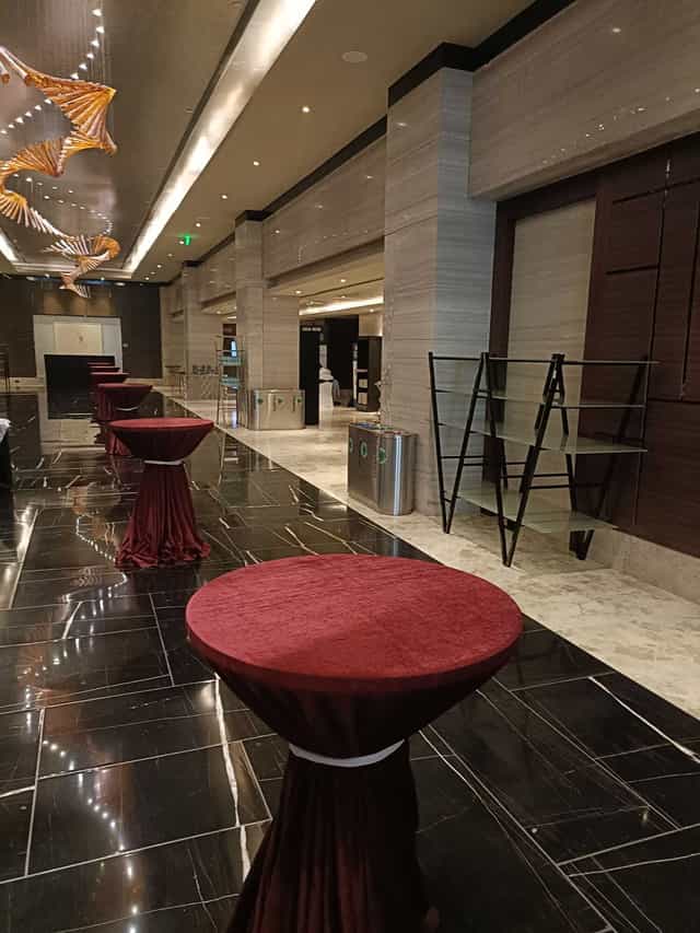 Sleek event space with red-draped tables for receptions and networking at Sheraton Grand.