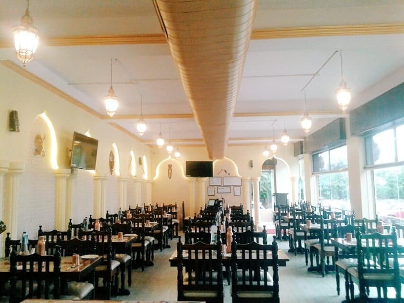 Outdoor seating in The Relish Lounge, featuring wooden tables for networking events.