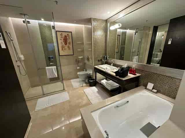 Modern hotel bathroom with shower and bathtub at JW Marriott Bengaluru for meetings.
