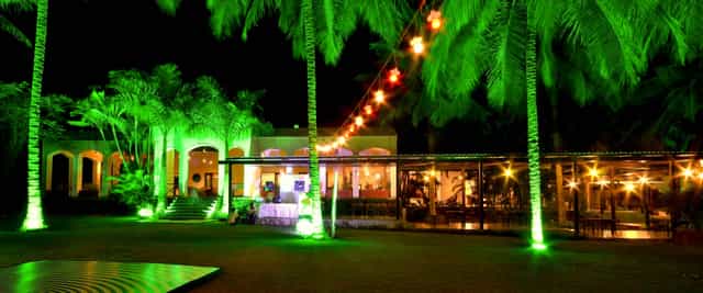 Outdoor board room with vibrant green lighting, perfect for weddings and corporate events.