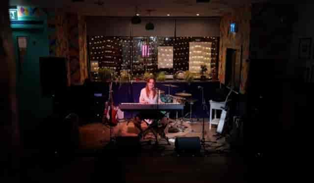 Cozy elysium Bar performer on stage, perfect for acoustic sessions or private events.