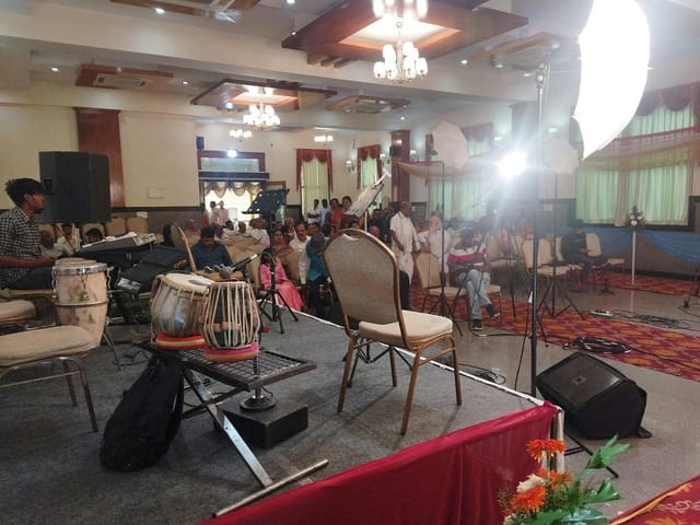 Prakruti Paradise Banquet Hall stage set for live performance event with inviting lighting.